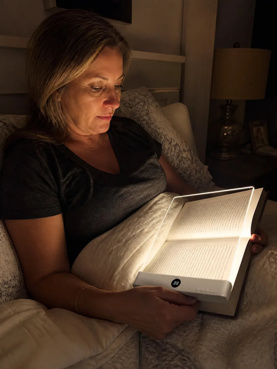 Reader using Lumalli for quiet late-night reading in bed