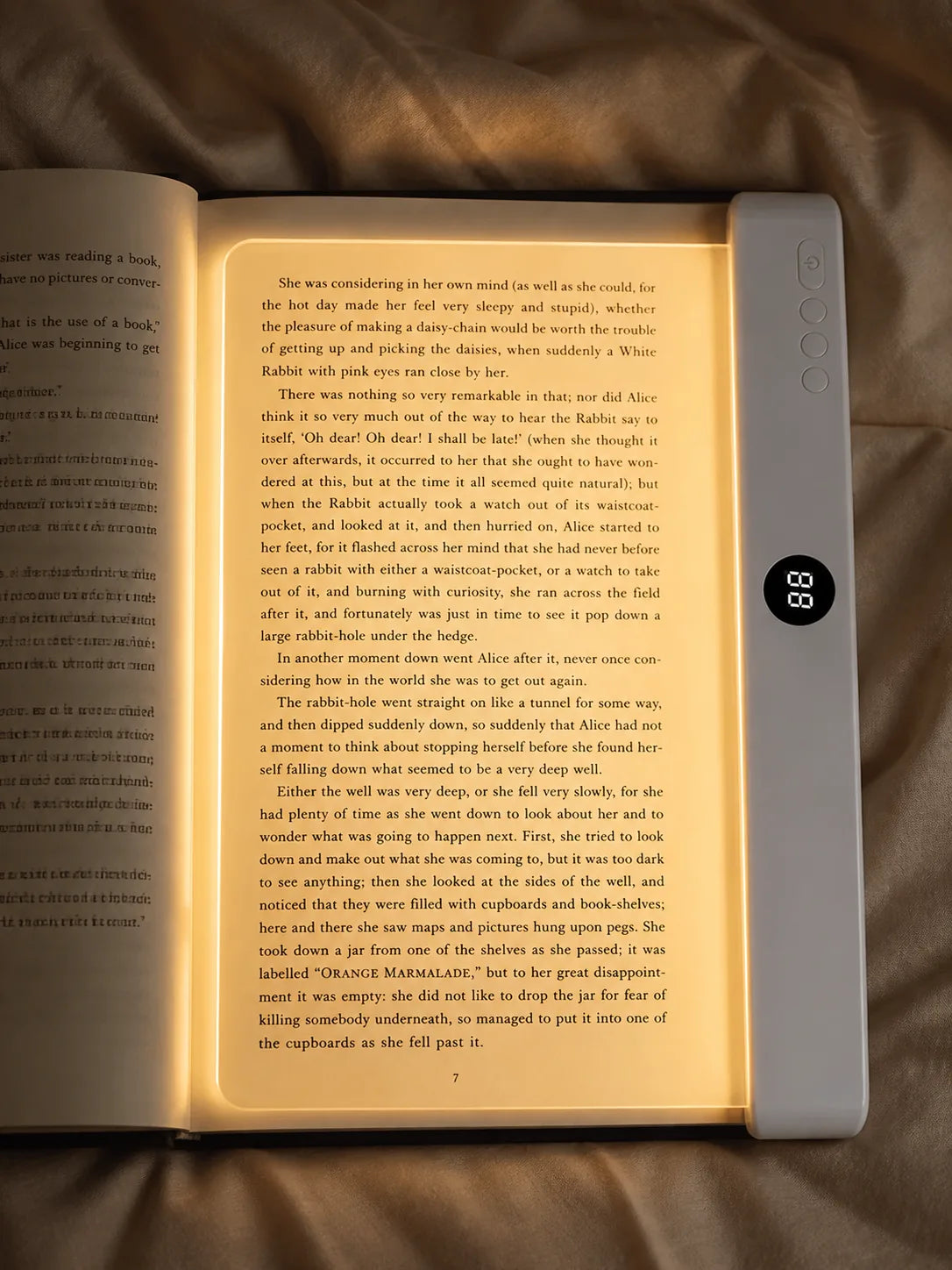 Lumalli lying flat over a book page with warm full-page illumination